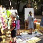 kleine Kinder malen an der Staffelei im Hof