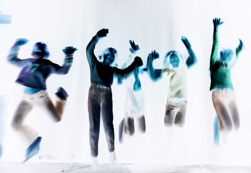 5 Kinder vor dunklem Hintergrund springen in die Luft. Das Foto wird in seiner Negative dargestellt, sodass keine Farben oder Gesichter zu erkennen sind