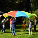 Kinder halten ein Schwungtuch in die Luft