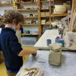 Junge arbeitet mit Ton in einer Werkstatt