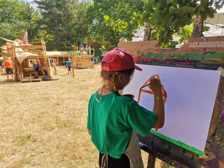 Mädchen malt ein Haus an einer Staffelei
