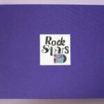 Lila Buchvover mit orangener Bindung, das den Buchtitel und eine kleine Schallplatte in einer Hülle zeigt