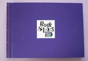 Lila Buchvover mit orangener Bindung, das den Buchtitel und eine kleine Schallplatte in einer Hülle zeigt