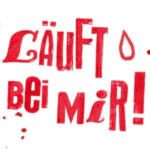Zu sehen ist ein gestempelter Schriftzug, der Kursname "Läuft bei mir!" in roter Schrift mit roten Klecksen.